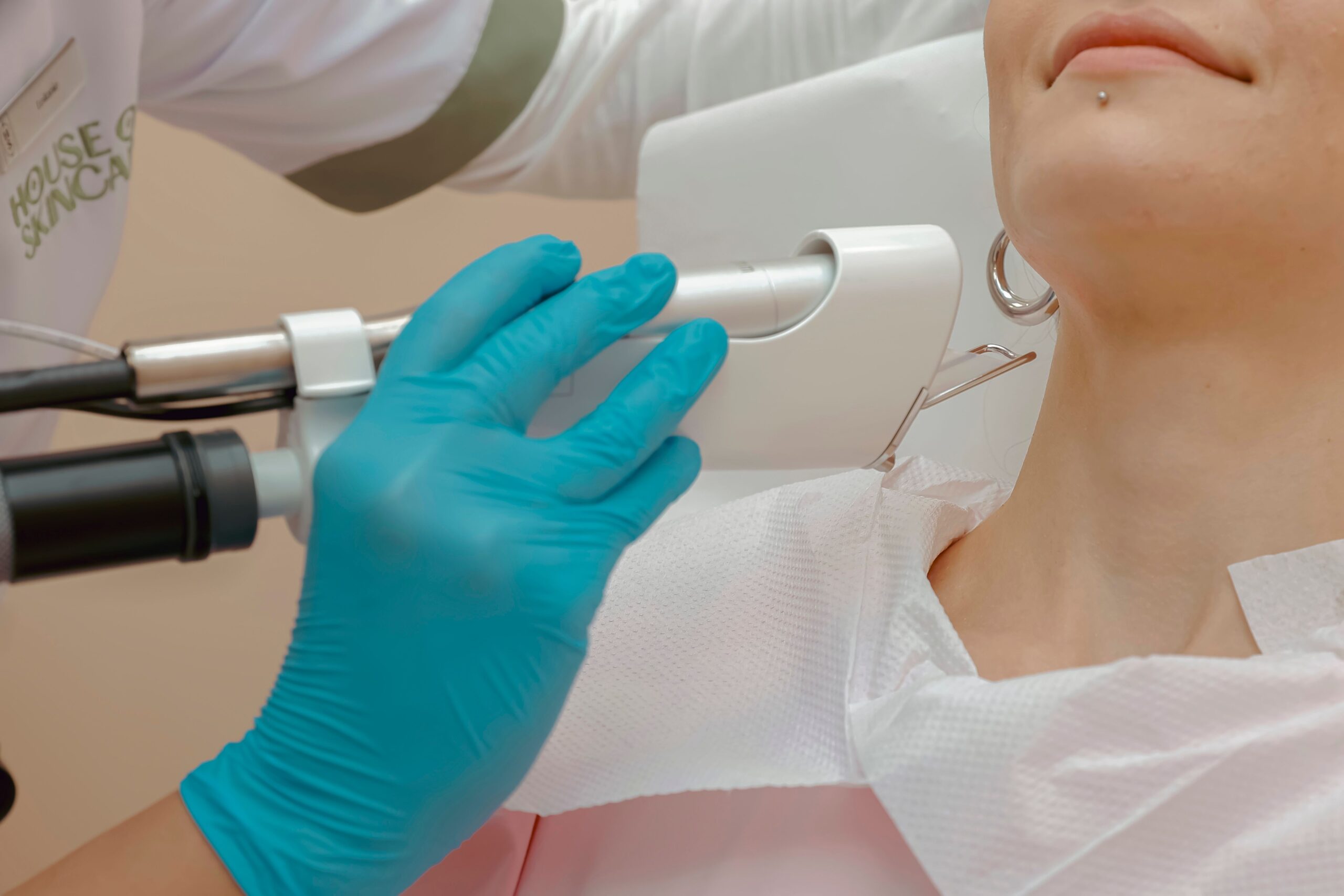 A patient during her laser skin treatment, close up of a hand and laser device